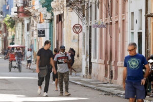 Personas caminan por una calle este jueves, en La Habana (Cuba). Cuba tendrá prolongados cortes eléctricos en todo el país este sábado, apagones que desconectarán a la vez hasta el 63 % de la isla en el momento de mayor demanda energética, según datos de la estatal Unión Eléctrica (UNE) elaborados por EFE